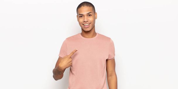 young black man looking proud, confident and happy, smiling and pointing to self or making number one sign - Valokuva, kuva