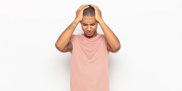 young black man feeling stressed and frustrated, raising hands to head, feeling tired, unhappy and with migraine - Foto, Imagen