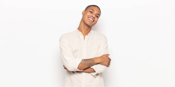 young black man laughing happily with arms crossed, with a relaxed, positive and satisfied pose - Foto, Imagem