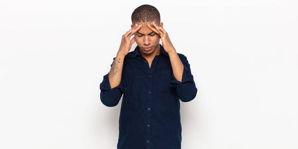 jonge zwarte man kijken gestresst en gefrustreerd, werken onder druk met hoofdpijn en verontrust met problemen - Foto, afbeelding