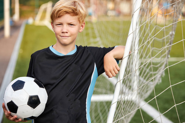 portrait of smiling caucasian kid boy with football ball in hands - Zdjęcie, obraz