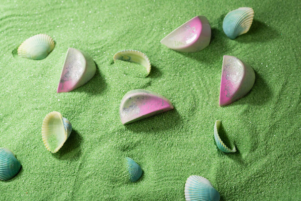 Modern candies on green sand and seashell - Foto, Bild