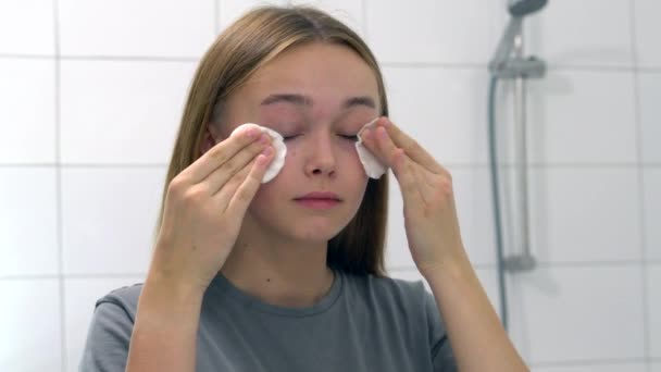 Mujer joven sostiene disco de almohadilla de algodón limpiando la piel de la cara limpia con limpiador. - Metraje, vídeo