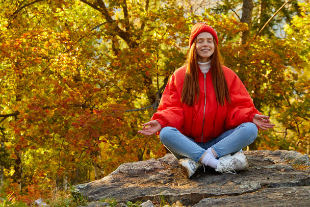 woman with natural red hair is meditating in nature - Photo, Image
