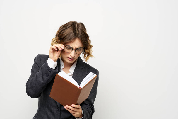 女性で仕事で本で手ライトバック古典的なスーツの眼鏡頭 - 写真・画像