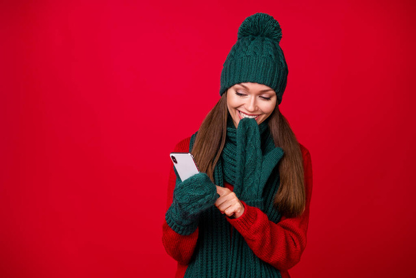 Portrait of her she nice attractive pretty cheerful cheery girl wearing wool clothes using gadget device app 5g blogging isolated over bright vivid shine vibrant red color background - 写真・画像