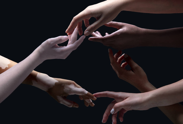 Hands of different people in touch isolated on black studio background. Concept of human relation, community, togetherness, inclusion - Photo, image
