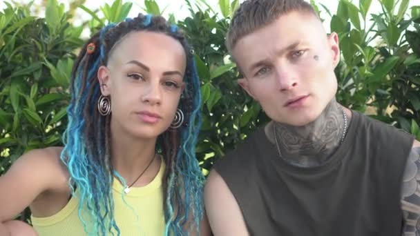 Portré a modern fiatal pár férfi és nő tetoválásokkal és divatos frizurák - Felvétel, videó
