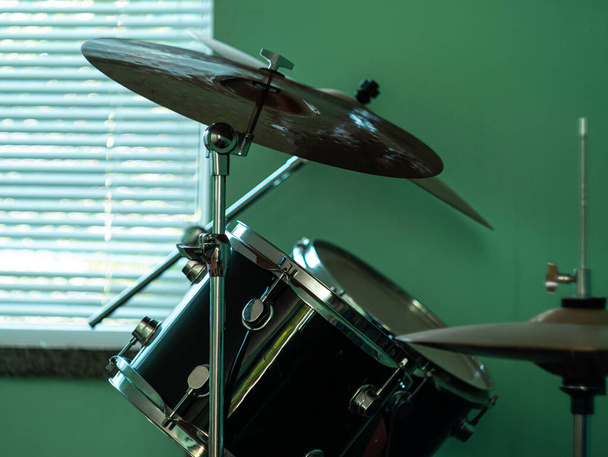 Black drum kit close-up. Musician set with mix of drums in studio. Musical instruments devices for drumming performance. Low key, dark and moody rock metal music style. - Photo, Image