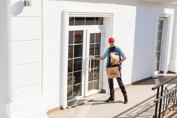 Delivery man delivering food to home - online grocery shopping service concept - Foto, Imagen