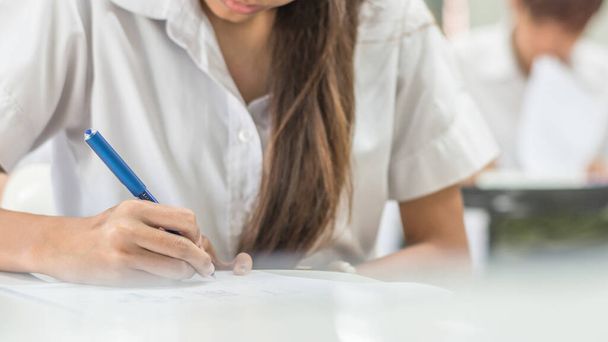 Homályos iskolai háttér egyetemi hallgatók írásban választ csinál vizsga osztályteremben - Fotó, kép