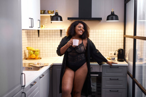 beautiful black lady drinking tea at home - Foto, imagen