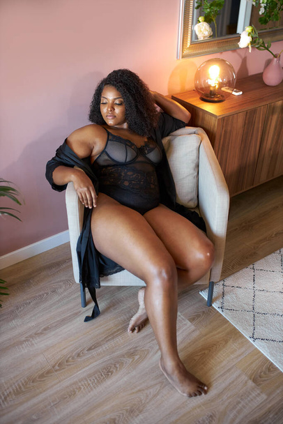 good-looking african woman with half naked plus size body sits on armchair - Foto, Imagen