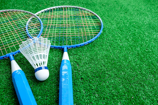 Due mini racchette badminton con navicella bianca sullo sfondo verde, giochi attivi. copia spazio. - Foto, immagini