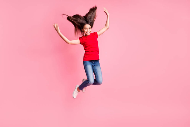 Full length photo of cheerful kid girl jump with flying long hairdo wear casual style outfit isolated over pastel color background - Photo, Image