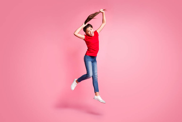 Full size photo of crazy kid girl jump make ponytail haircut wear red casual style clothes isolated over pastel color background - Foto, Imagem
