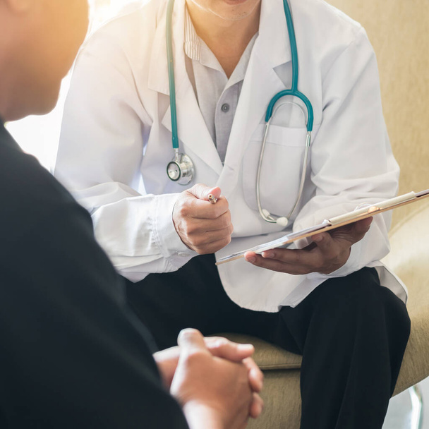 Male patient having consultation with doctor or psychiatrist who working on diagnostic examination on men's health disease or mental illness in medical clinic or hospital mental health service center - Photo, Image