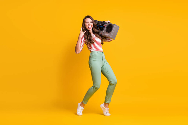 Full length body size photo of girl listening to retro boombox showing horns heavy metal sign isolated on vibrant yellow color background - Foto, Imagen