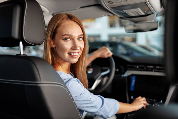 Happy woman new car owner sitting in driver seat - 写真・画像