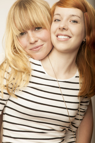 Red and blond haired girls friends laugh and hug - Photo, Image