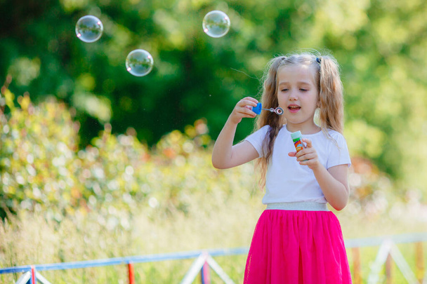 девушка летом надувает мыльные пузыри в парке - Фото, изображение
