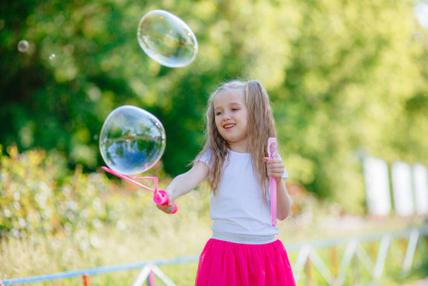 девушка летом надувает мыльные пузыри в парке - Фото, изображение