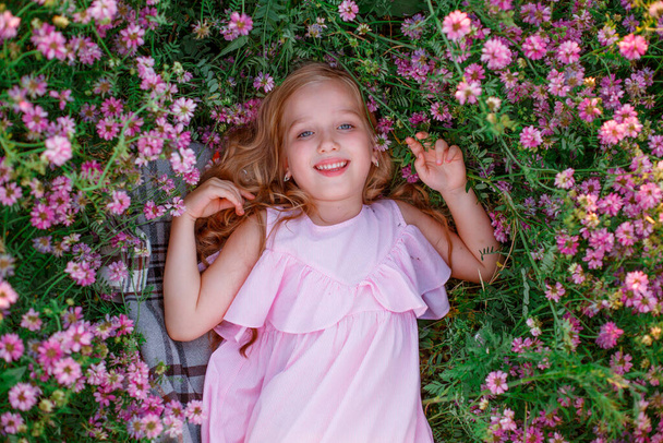 portret van een meisje in een weide met bloemen  - Foto, afbeelding