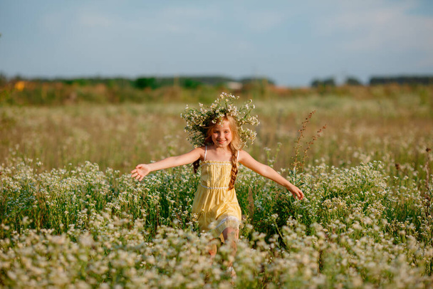 красива дівчина позує на полі в квітковому вінку
 - Фото, зображення
