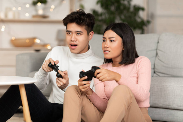 Chinois Millennial Couple Jouer jeu d'ordinateur assis à la maison - Photo, image