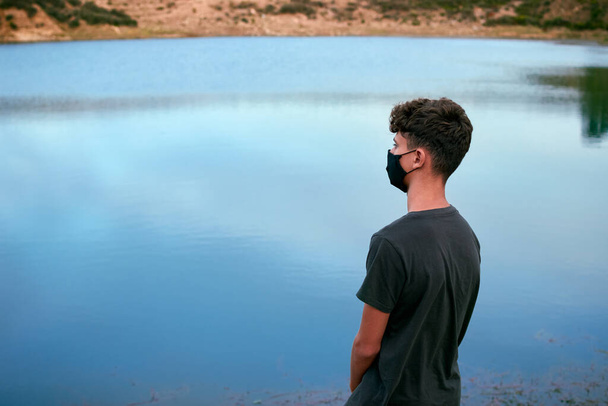 Молодой кавказский человек наслаждается видом на озеро - Фото, изображение