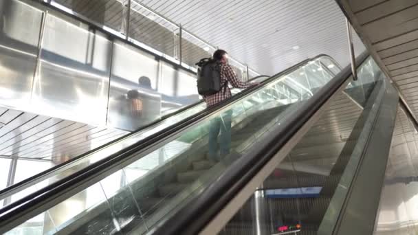Κενό κτίριο τρένου, μοναχικός επιβάτης στις κυλιόμενες σκάλες φορώντας προστατευτική μάσκα κατά τη διάρκεια πλήρους απομόνωσης. Ακύρωση πτήσεων και κατάρρευση μεταφορών covid 19. Επιβάτης στις κυλιόμενες σκάλες - Πλάνα, βίντεο