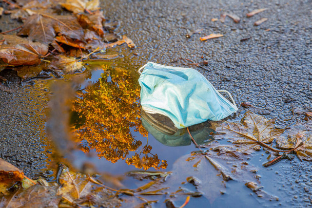 Atemschutzmaske liegt auf einem Weg im Park - Foto, Bild