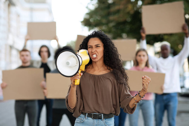 Manifestants multiraciaux frappant dans la rue, tenant un mégaphone et des pancartes - Photo, image