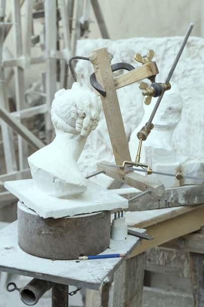 detal tradycyjnej trójwymiarowej grawerki na stole roboczym rzeźbiarza, nakręconej w Carrara, Toskania, Włochy - Zdjęcie, obraz