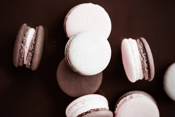 Macarons français sur fond chocolat au lait, dessert au café chic parisien, nourriture sucrée et macaron gâteau pour la marque de confiserie de luxe, décor de vacances - Photo, image