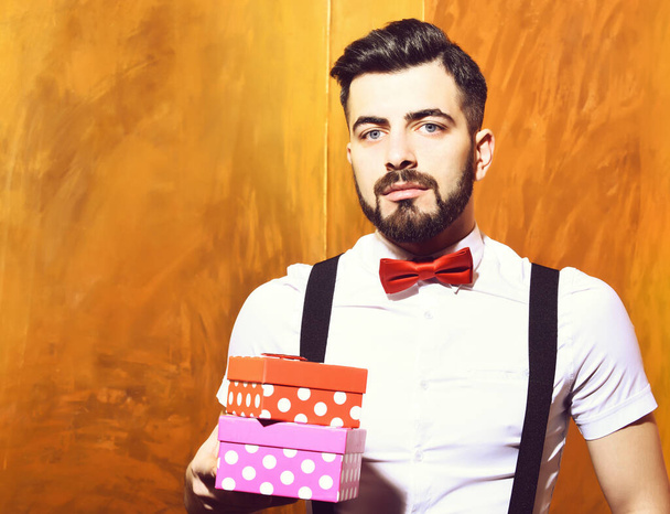 bearded man holding present boxes with serious face - Foto, Imagen