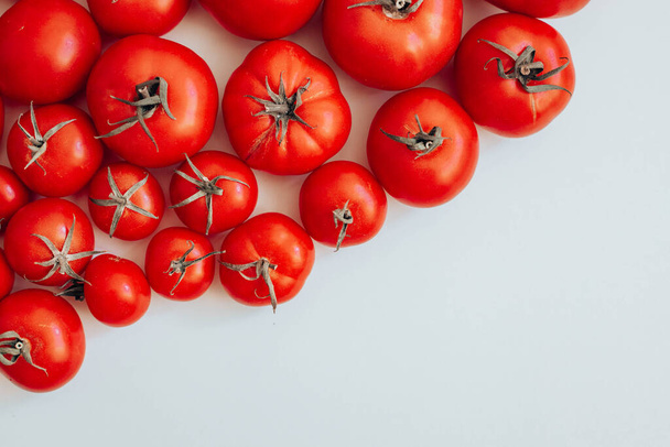 Kypsät erikokoiset tomaatit valkoisella pohjalla kopiotilaa. Luonnonmukaiset vihannekset. - Valokuva, kuva