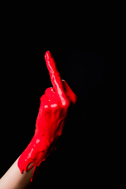 vista cortada da mão pintada em tinta vermelha mostrando dedo médio isolado em preto - Foto, Imagem