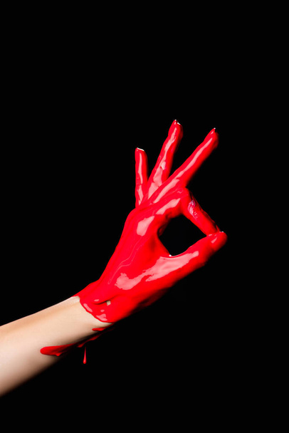 vista ritagliata di dipinto a mano in vernice rossa mostrando segno ok isolato su nero - Foto, immagini
