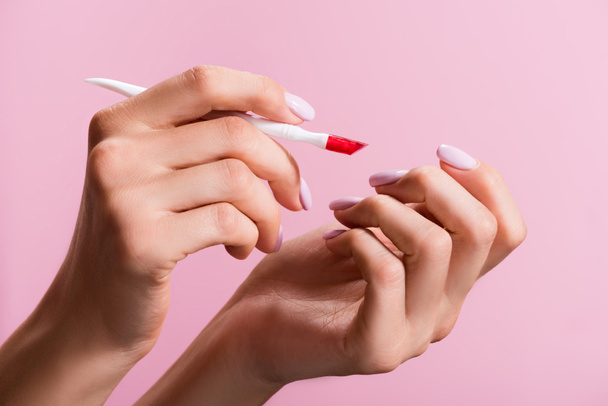 cropped view of woman using cuticle pusher isolated on pink - Fotografie, Obrázek
