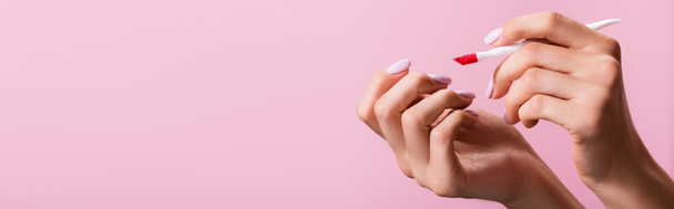 cropped view of woman holding cuticle pusher isolated on pink, banner - Fotografie, Obrázek