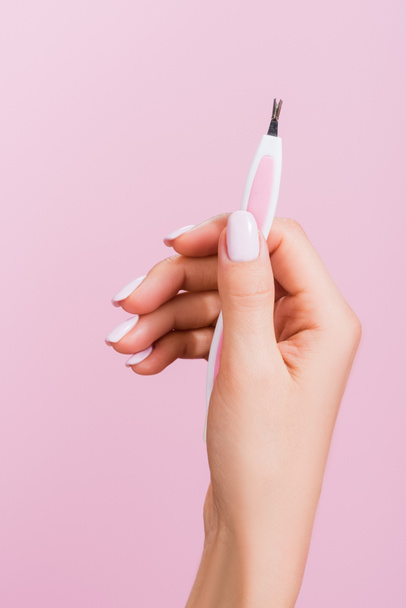 cropped view of woman holding cuticle clipper isolated on pink - 写真・画像