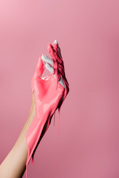 vista cortada da mão com tinta gotejamento isolado em rosa - Foto, Imagem