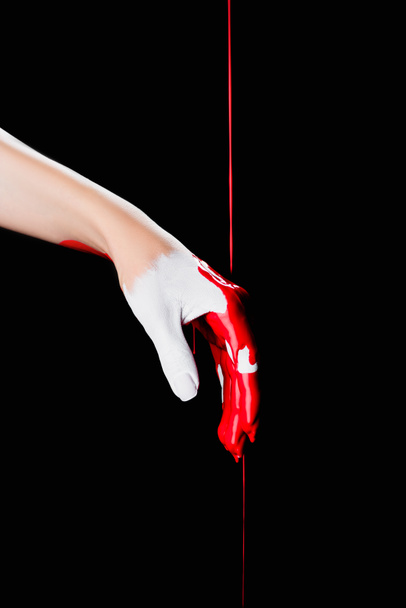 μερική άποψη του λευκού ζωγραφισμένο χέρι με κόκκινο χρώμα που στάζει απομονώνονται σε μαύρο - Φωτογραφία, εικόνα