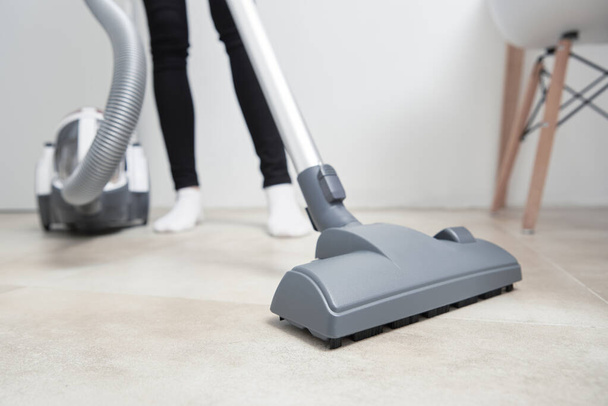 Woman using vacuum cleaner at the floor - Photo, Image