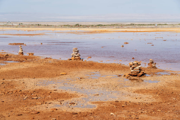 Terreno fangoso con acqua sorgiva, con pile di pietre su un lato. Foto in Qinghai, Cina. - Foto, immagini