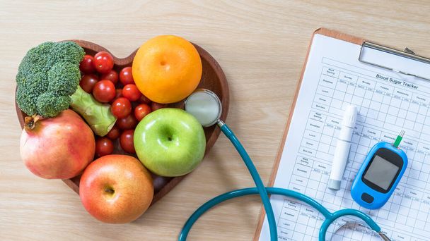 Cukorbetegség-monitor, koleszterin diéta és egészséges táplálkozás táplálkozás táplálkozási koncepció tiszta gyümölcsökkel a táplálkozási szakember szívételében és a beteg vércukorszint-szabályozó készletével - Fotó, kép