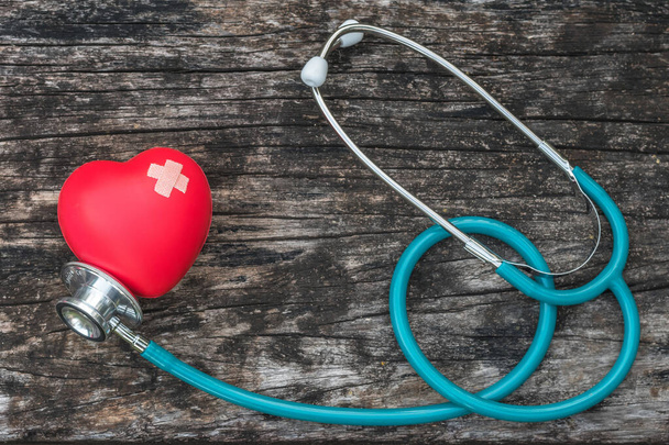 Seguro de salud y el concepto del día de la salud mundial con amor corazón rojo con vendaje cruzado y estetoscopio médico médico  - Foto, imagen