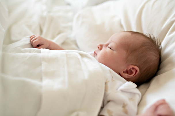 A Sweet newborn baby girl sleeping in white bed - Photo, image