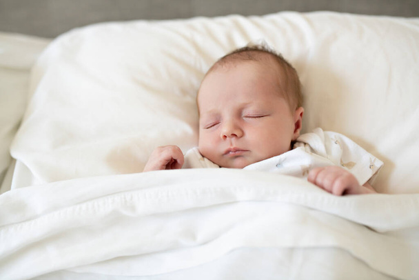 A Sweet newborn baby girl sleeping in white bed - Foto, Imagen
